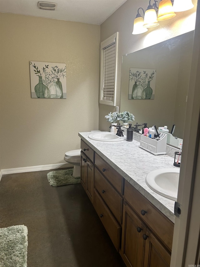 bathroom featuring baseboards, a sink, toilet, and double vanity