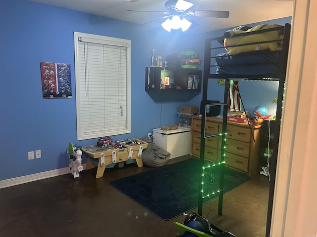 bedroom featuring a ceiling fan, baseboards, and concrete flooring