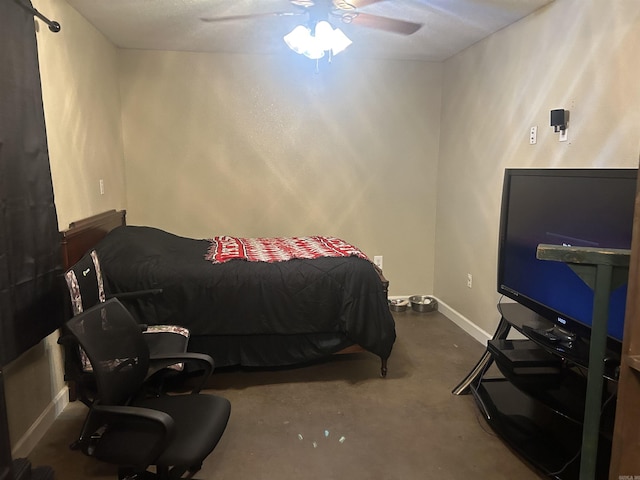 bedroom featuring ceiling fan, baseboards, and concrete flooring