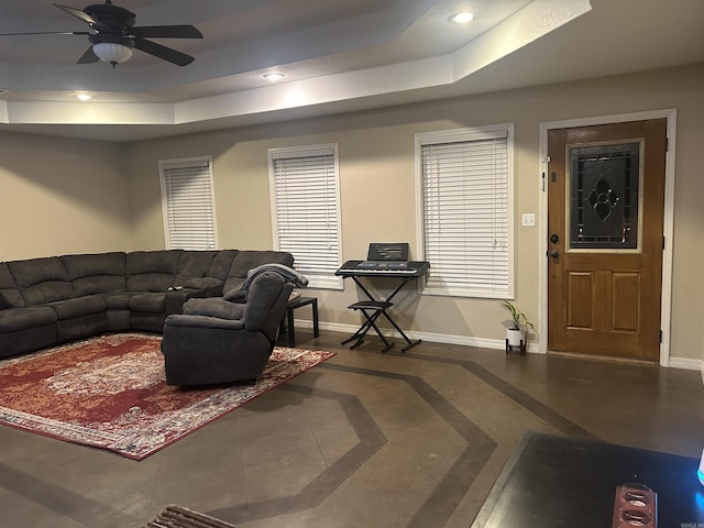 living area with baseboards, a raised ceiling, a ceiling fan, and recessed lighting