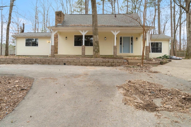 view of front of property featuring covered porch and a chimney