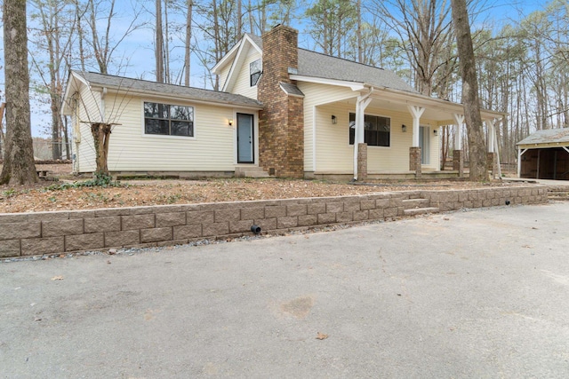 view of front of property with a porch and a chimney