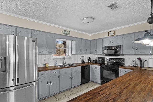 kitchen featuring visible vents, gray cabinets, black appliances, wooden counters, and a sink