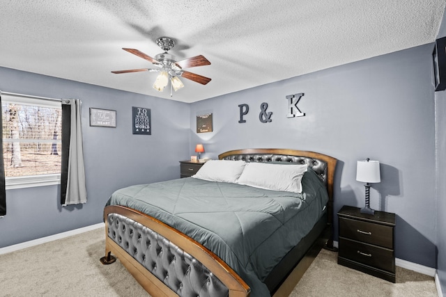 bedroom with light colored carpet, ceiling fan, a textured ceiling, and baseboards