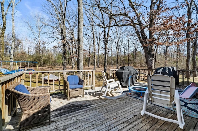 wooden deck featuring area for grilling and a playground