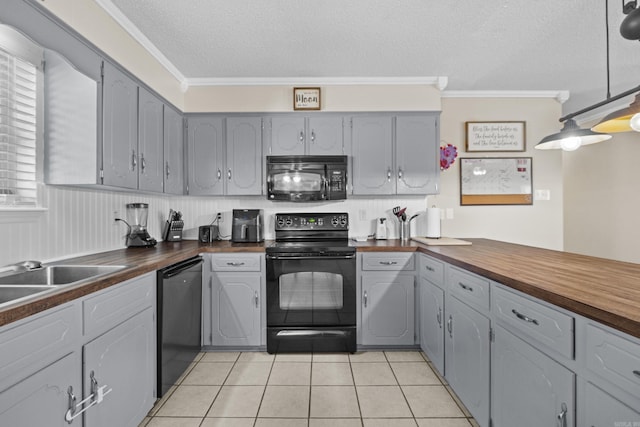 kitchen with black appliances, butcher block countertops, ornamental molding, and gray cabinets