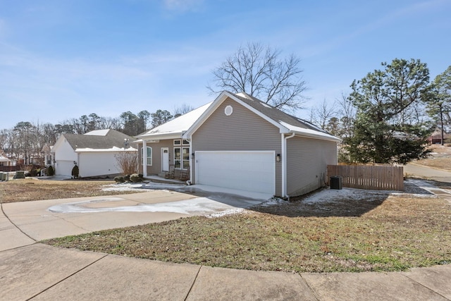 ranch-style home with an attached garage, cooling unit, fence, and concrete driveway