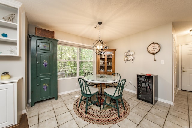 dining area with light tile patterned floors, beverage cooler, a chandelier, and baseboards