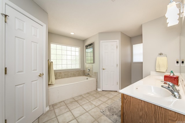 full bath featuring a bath, double vanity, a sink, and tile patterned floors