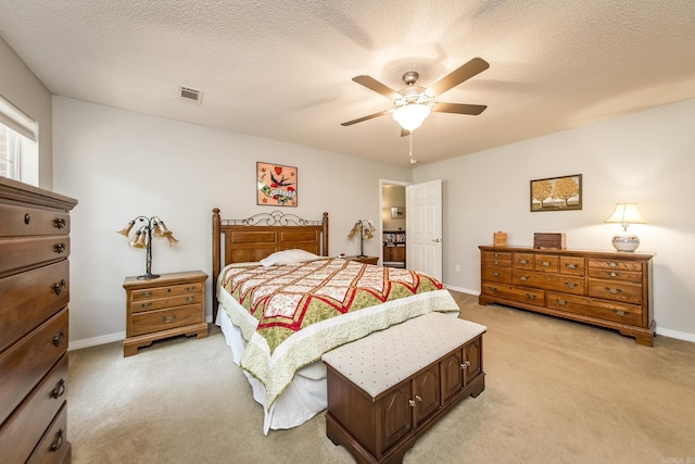 bedroom featuring baseboards, visible vents, a textured ceiling, and light colored carpet