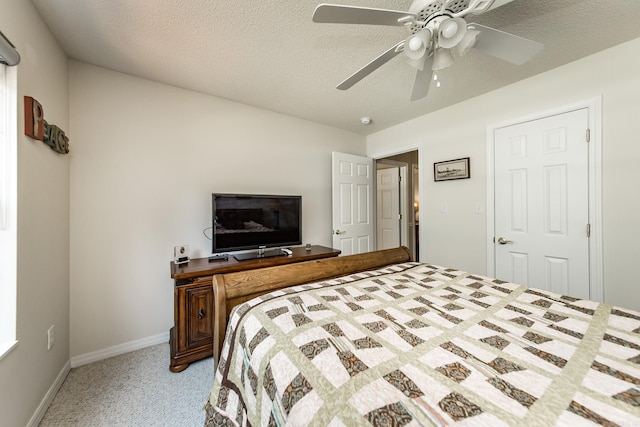 bedroom with a textured ceiling, ceiling fan, baseboards, and light colored carpet