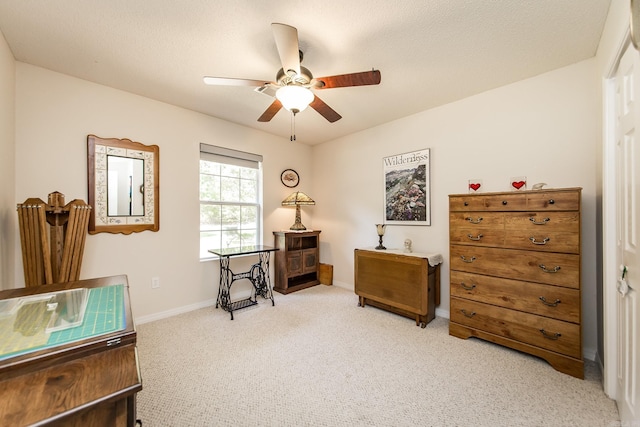 interior space with light colored carpet, ceiling fan, a textured ceiling, and baseboards