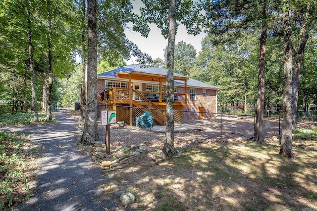 back of house with stairs, fence, a deck, and brick siding