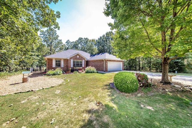 single story home featuring driveway, brick siding, a front lawn, and an attached garage