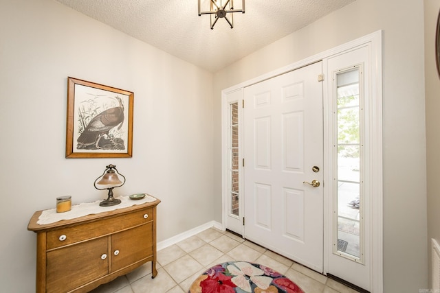 entryway with baseboards, a textured ceiling, and light tile patterned flooring