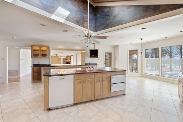 kitchen with dishwasher, dark countertops, an island with sink, glass insert cabinets, and a sink