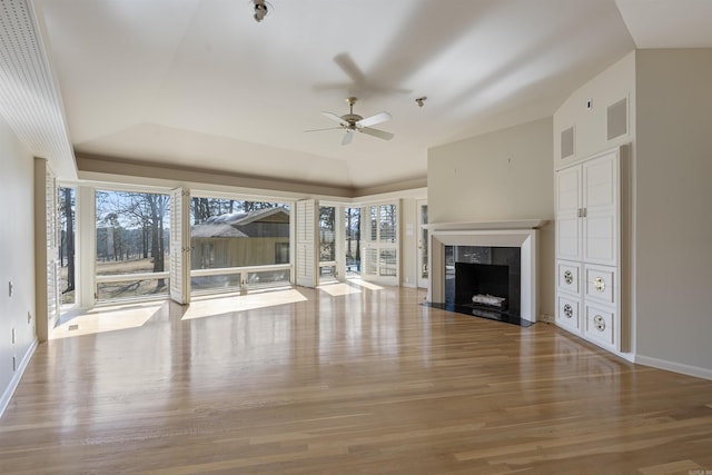 unfurnished living room featuring visible vents, a premium fireplace, light wood-type flooring, and a wealth of natural light