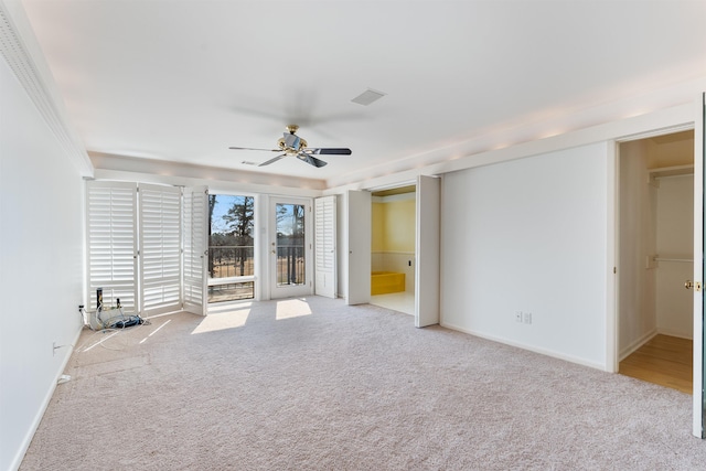 unfurnished room with visible vents, baseboards, a ceiling fan, and light colored carpet