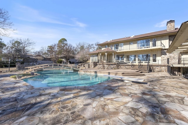 view of pool with a diving board, a patio area, fence, and a fenced in pool