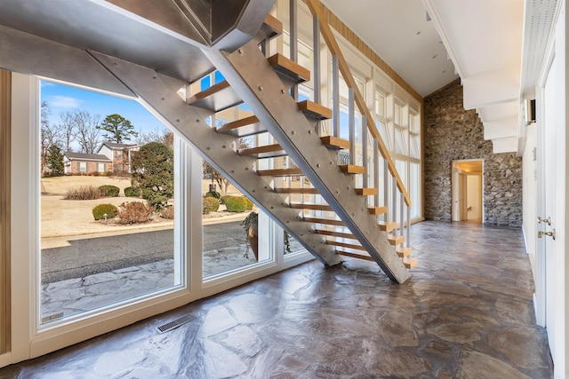 staircase with a towering ceiling and visible vents