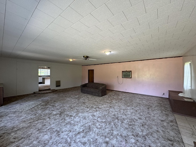 unfurnished living room featuring ceiling fan, a wall mounted AC, and carpet flooring