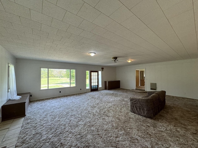 unfurnished living room with carpet flooring and a ceiling fan