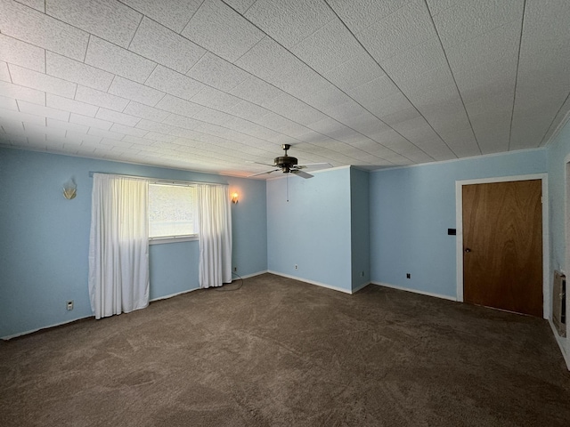 empty room featuring dark colored carpet and ceiling fan