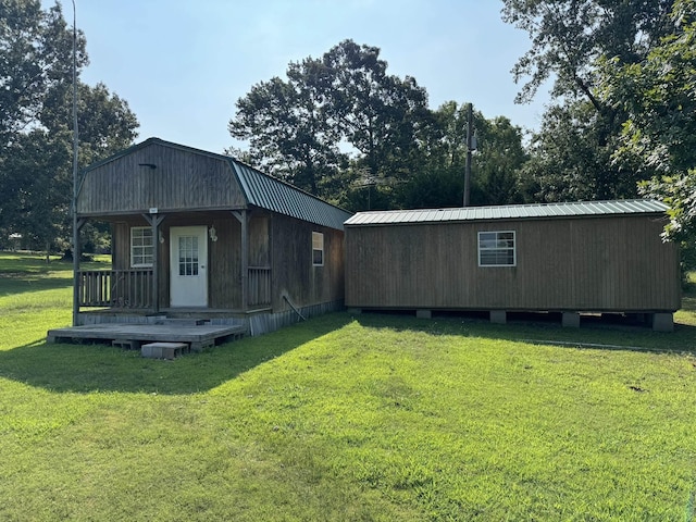 view of front facade with a gambrel roof, metal roof, and a front yard