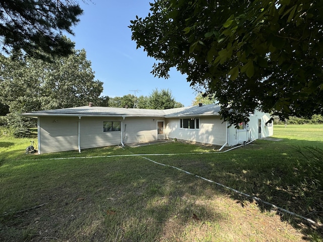 rear view of house featuring a lawn