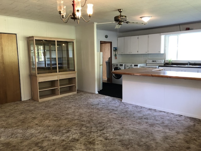 kitchen with carpet floors, white range with electric stovetop, hanging light fixtures, white cabinetry, and separate washer and dryer