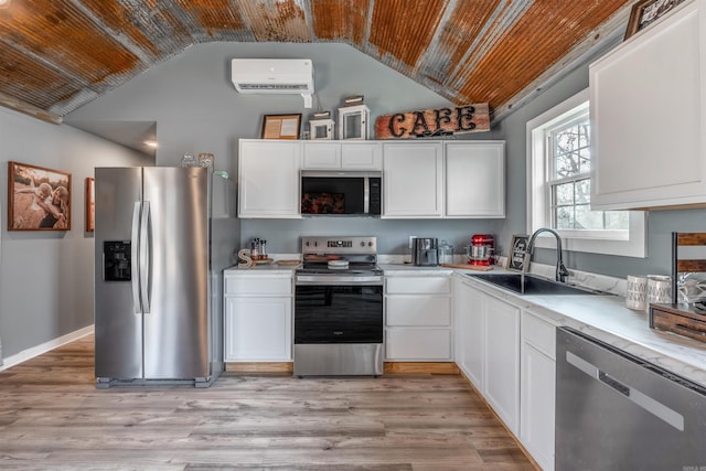 kitchen featuring a sink, light wood-style floors, white cabinets, light countertops, and appliances with stainless steel finishes