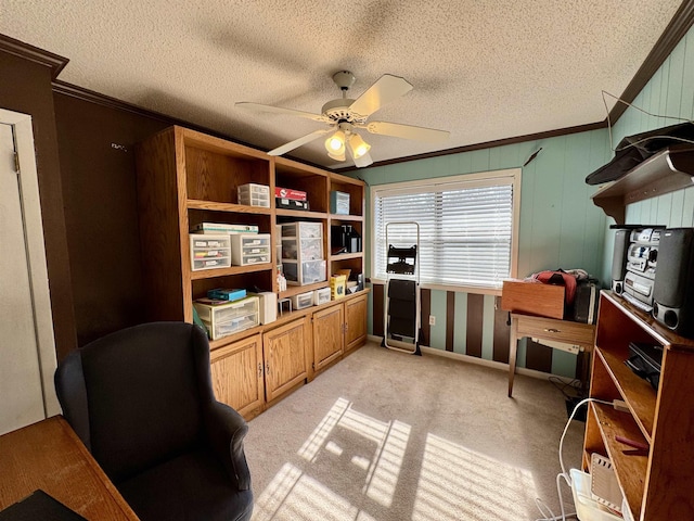 home office with light carpet, a ceiling fan, ornamental molding, and a textured ceiling