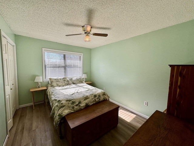 bedroom featuring a textured ceiling, dark wood finished floors, a ceiling fan, and baseboards