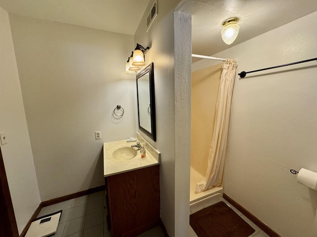 full bathroom featuring a shower stall, visible vents, baseboards, and vanity