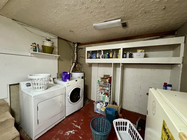 laundry room with laundry area, water heater, a textured ceiling, and independent washer and dryer