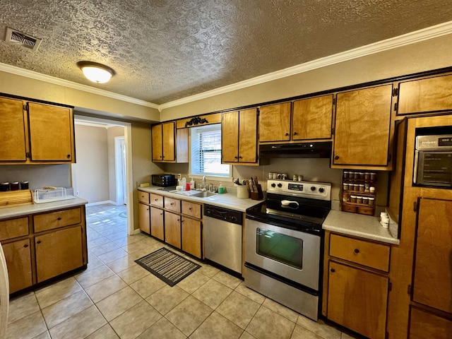 kitchen featuring appliances with stainless steel finishes, light countertops, a sink, and under cabinet range hood