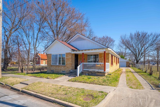 view of front of home featuring crawl space, fence, a porch, board and batten siding, and brick siding