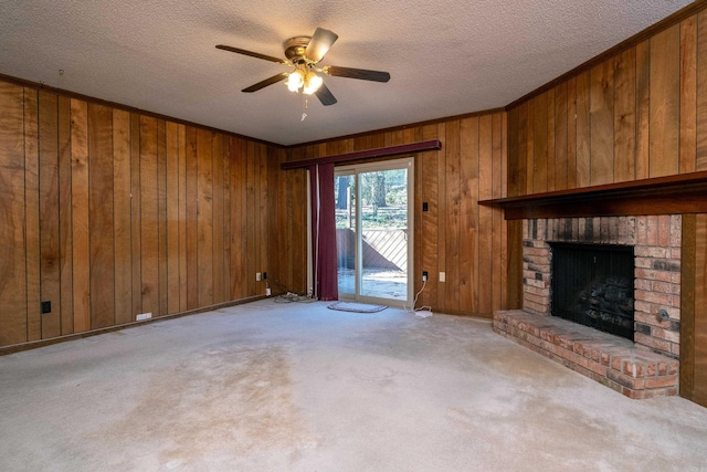 unfurnished living room with light carpet, a brick fireplace, a textured ceiling, and wood walls