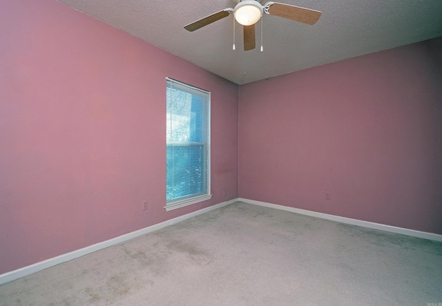 unfurnished room with light carpet, ceiling fan, a textured ceiling, and baseboards