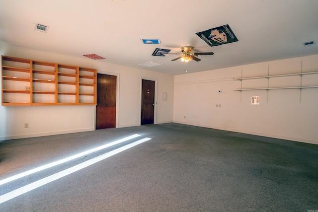 garage featuring a ceiling fan, visible vents, and baseboards