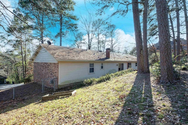 rear view of property featuring brick siding and a chimney