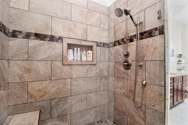 full bath with a tile shower and vanity