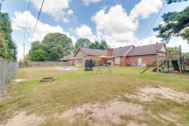 view of yard with an outdoor fire pit, a fenced backyard, a playground, and a swimming pool