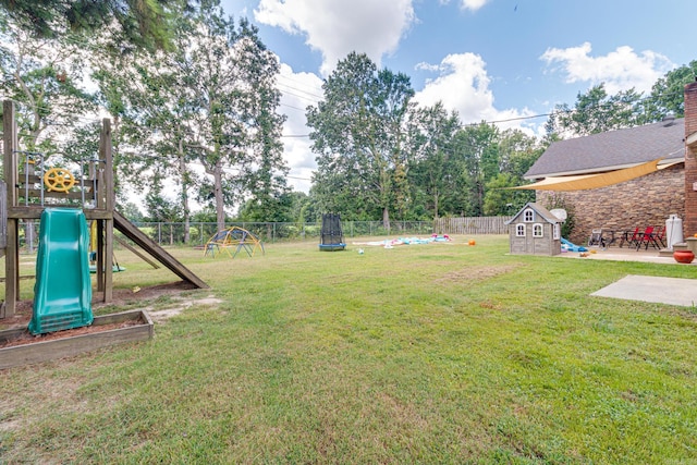 view of yard with a patio area, a trampoline, a playground, and a fenced backyard