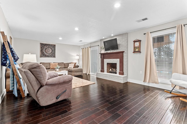 living area with recessed lighting, a fireplace, dark wood finished floors, and visible vents