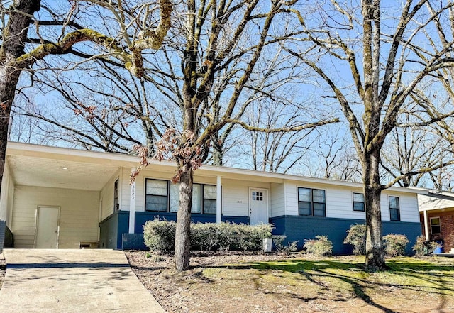 ranch-style home with an attached carport, concrete driveway, and brick siding