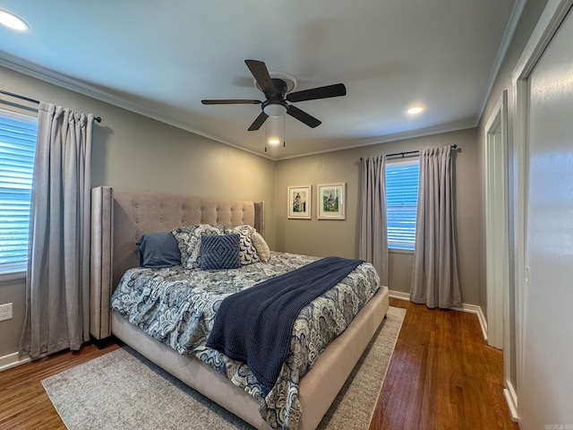 bedroom featuring baseboards, dark wood finished floors, a ceiling fan, and crown molding