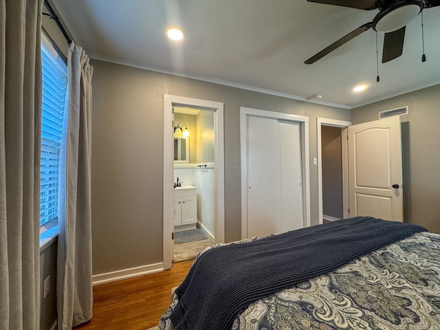 bedroom with ceiling fan, connected bathroom, baseboards, ornamental molding, and dark wood finished floors