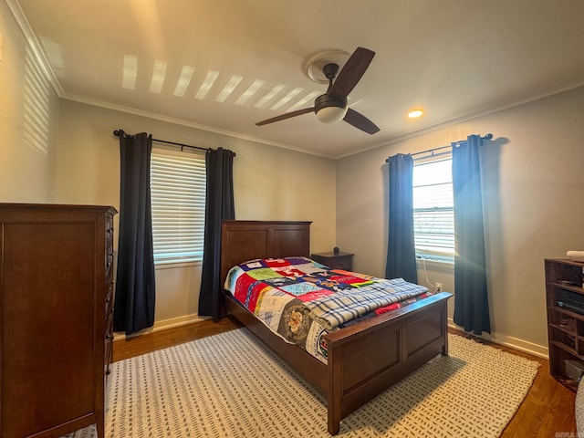 bedroom with a ceiling fan, crown molding, baseboards, and wood finished floors