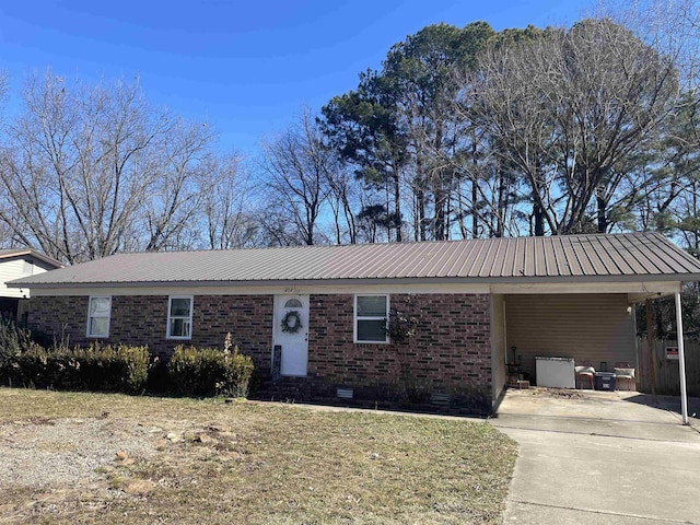 ranch-style home with metal roof, concrete driveway, and brick siding